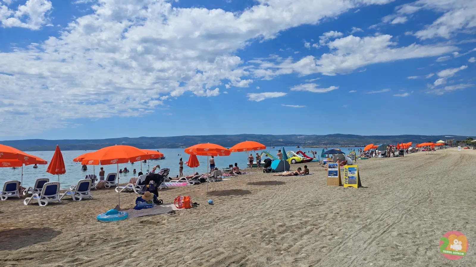 Velika Plaža in Omiš with a sandy shore, orange parasols and sunbeds by the sea