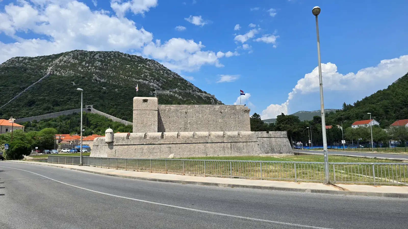 Kaštio fortress in Ston, with the Ston wall zigzagging up the hill behind it