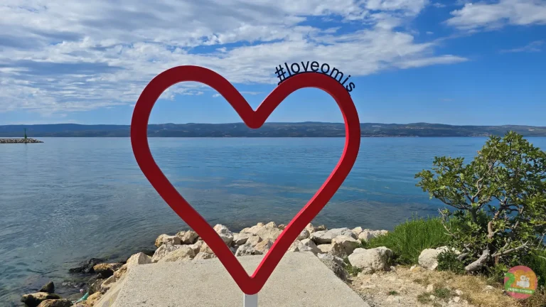 Red heart with #loveomis on the coast of Omiš in Croatia overlooking the sea