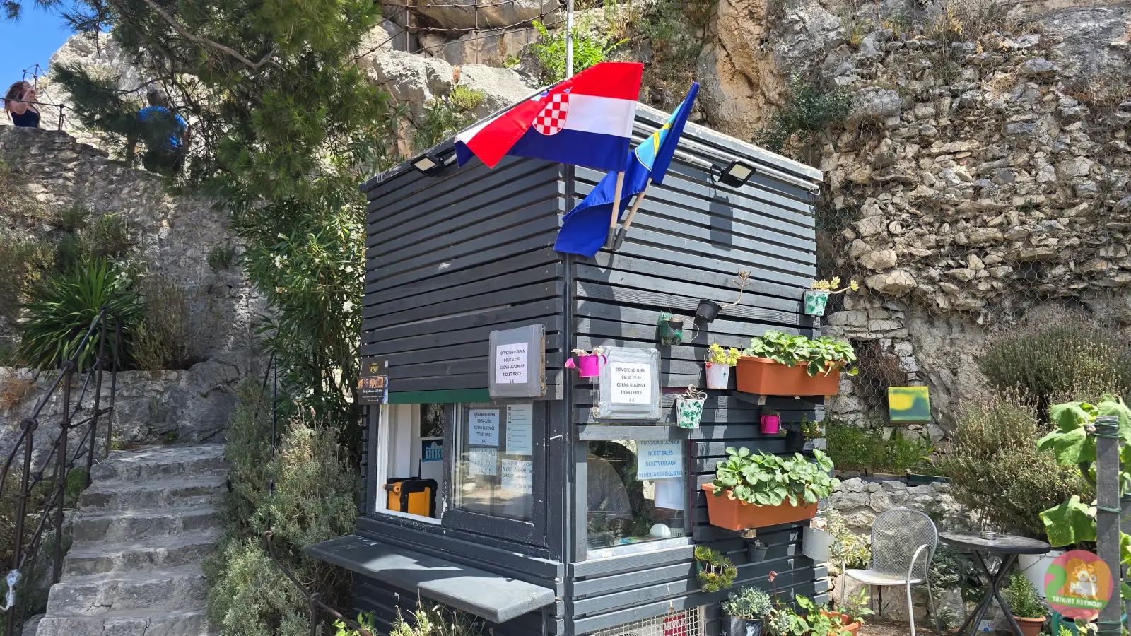 Mala blagajna tvrđave Mirabela u Omišu s hrvatskom zastavom i teglama s cvijećem